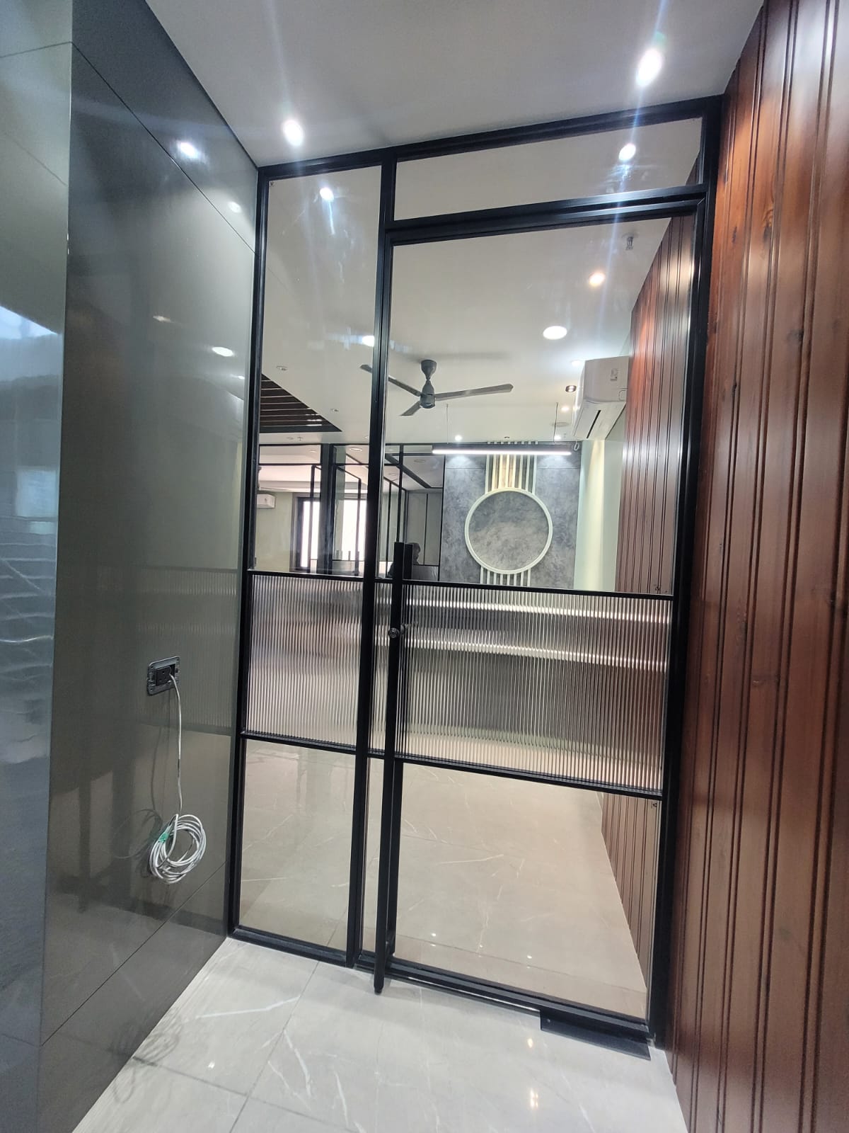 Modern office with steel frame glass partition and wood panelling, Delhi NCR