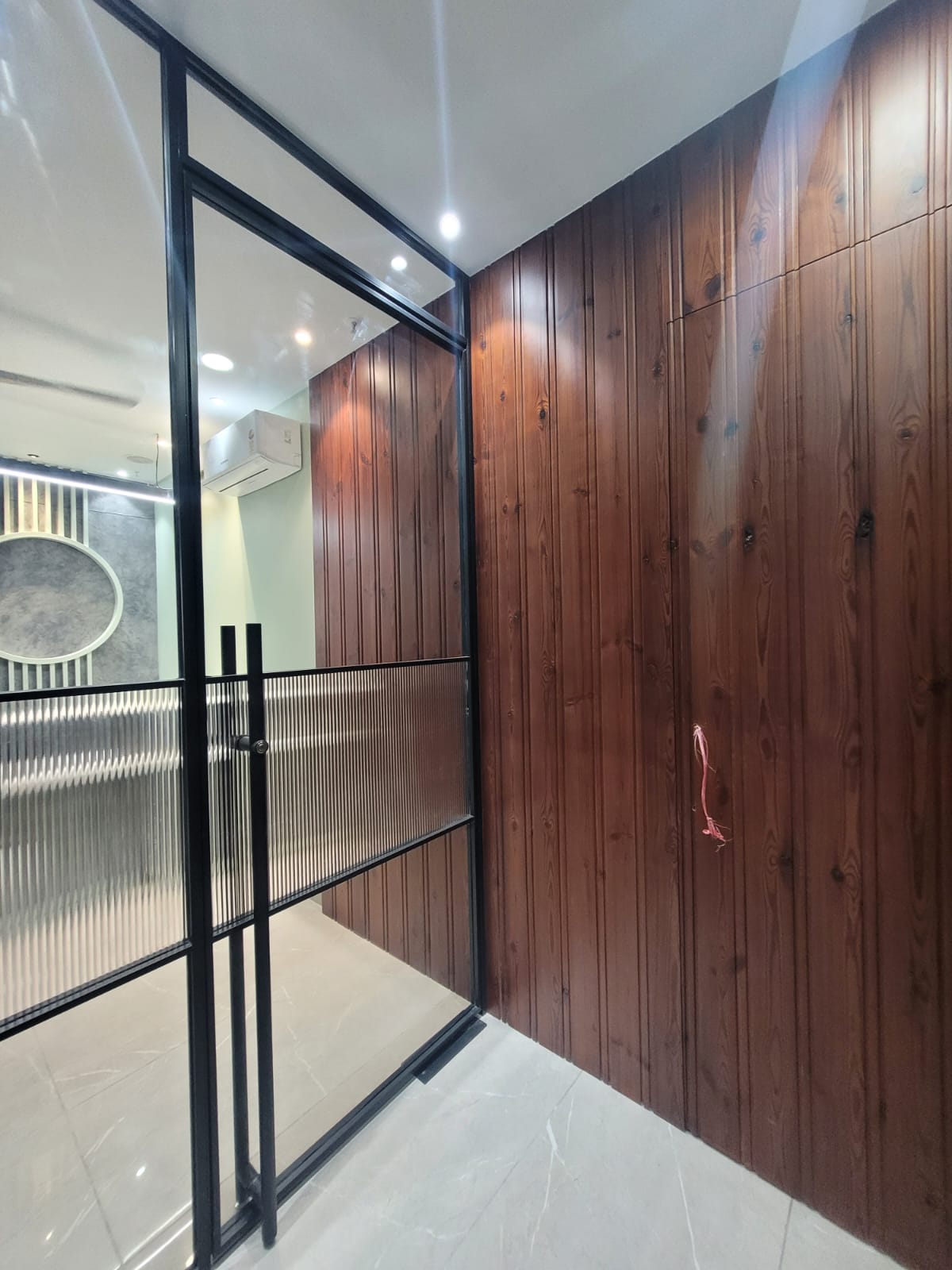 Contemporary office interior with wood cladding and glass partition, Noida