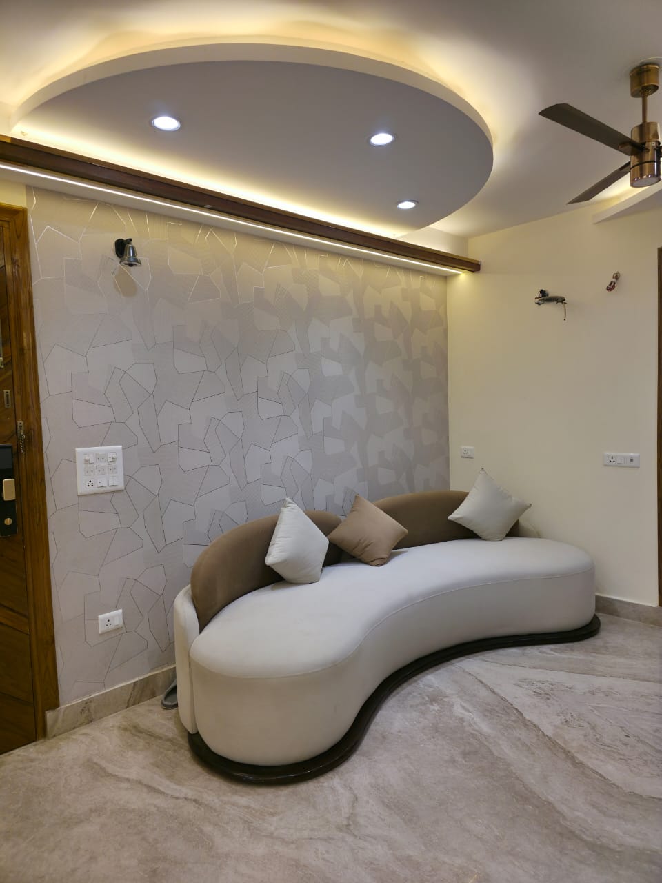 Living room with curved sofa geometric wallpaper and oval false ceiling, Ghaziabad