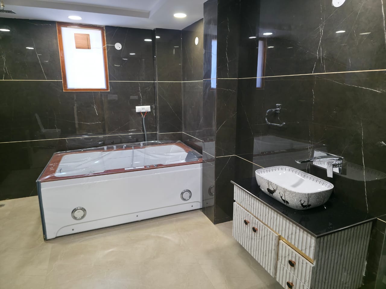 Luxury bathroom with jacuzzi and black marble tiles, Ghaziabad