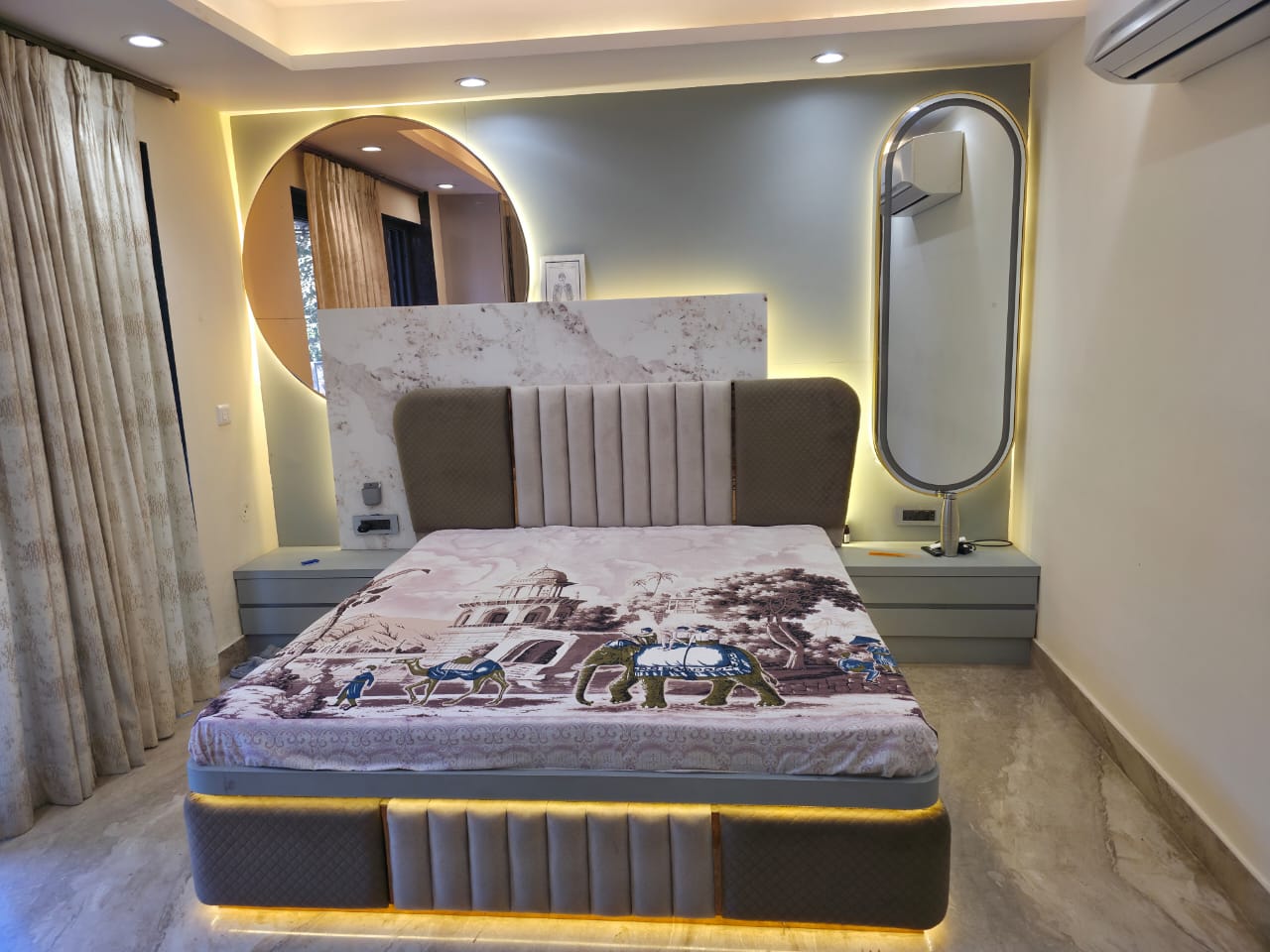 Master bedroom with circular backlit mirror and upholstered headboard, Noida