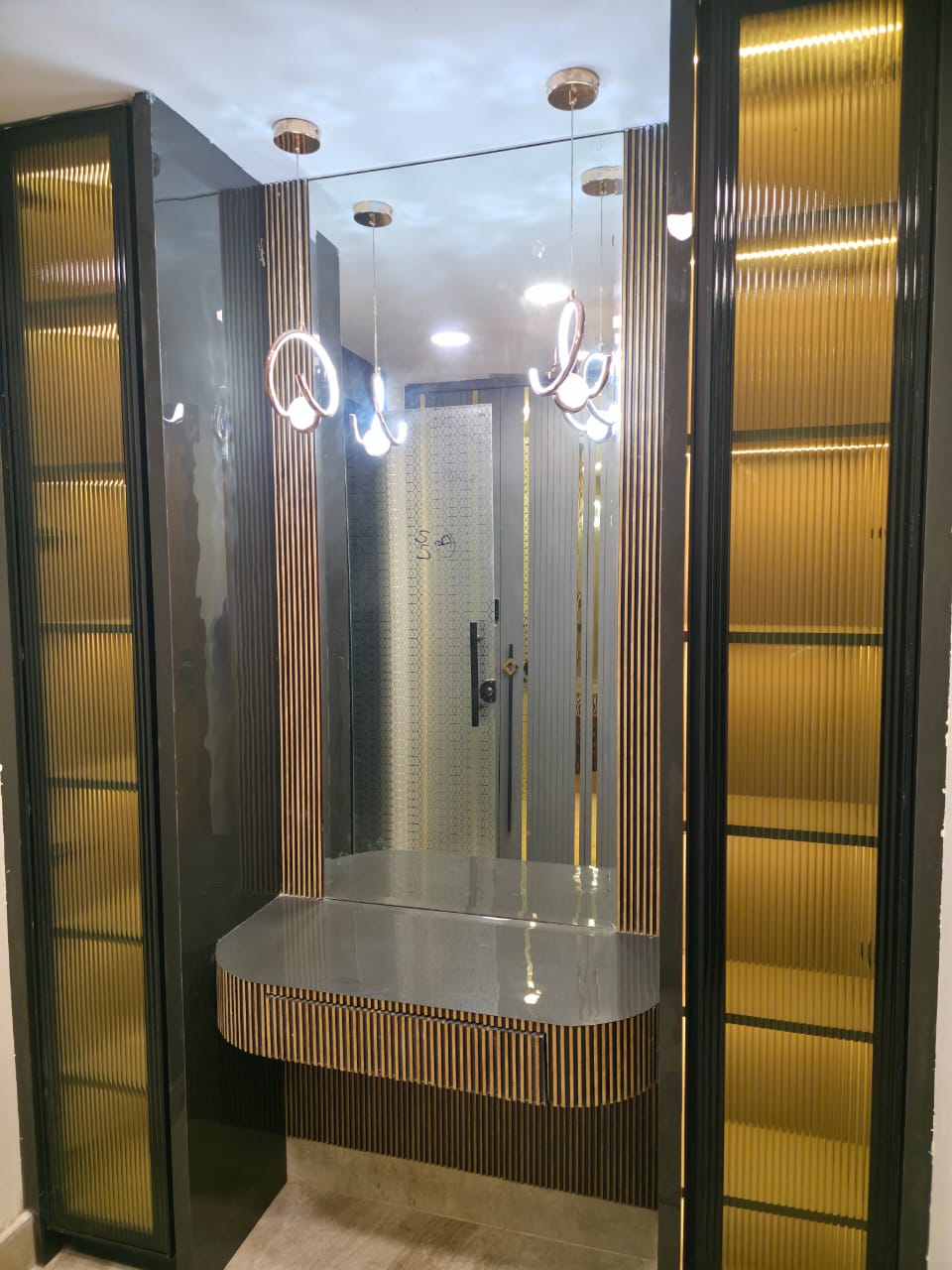 Luxury entrance foyer with gold ribbed cabinets and pendant lights, Delhi