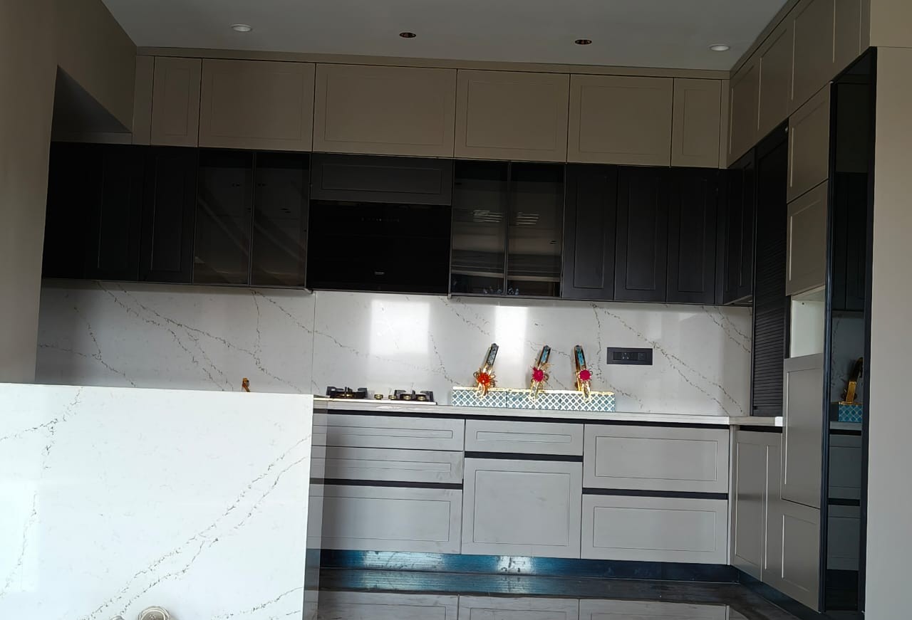 Modular kitchen with dark cabinets and marble backsplash, Ghaziabad